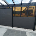 Outdoor patio area with a black privacy screen and tiled floor.