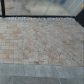 Paved area with stone tiles and a glass door in the background