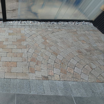 Paved area with stone tiles and a glass door in the background
